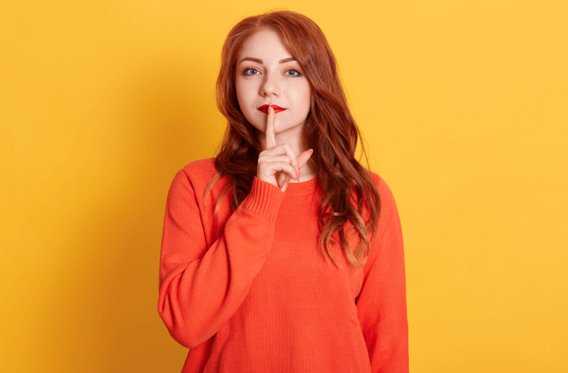 Red hair woman with finger on her lip (1)